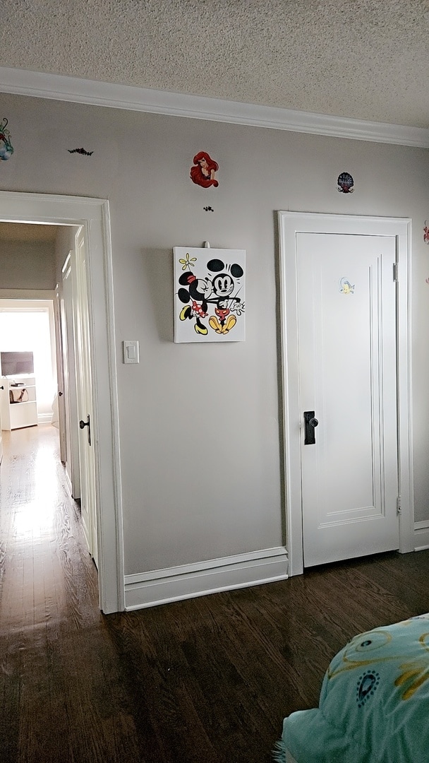 interior space featuring a textured ceiling, crown molding, and dark hardwood / wood-style flooring