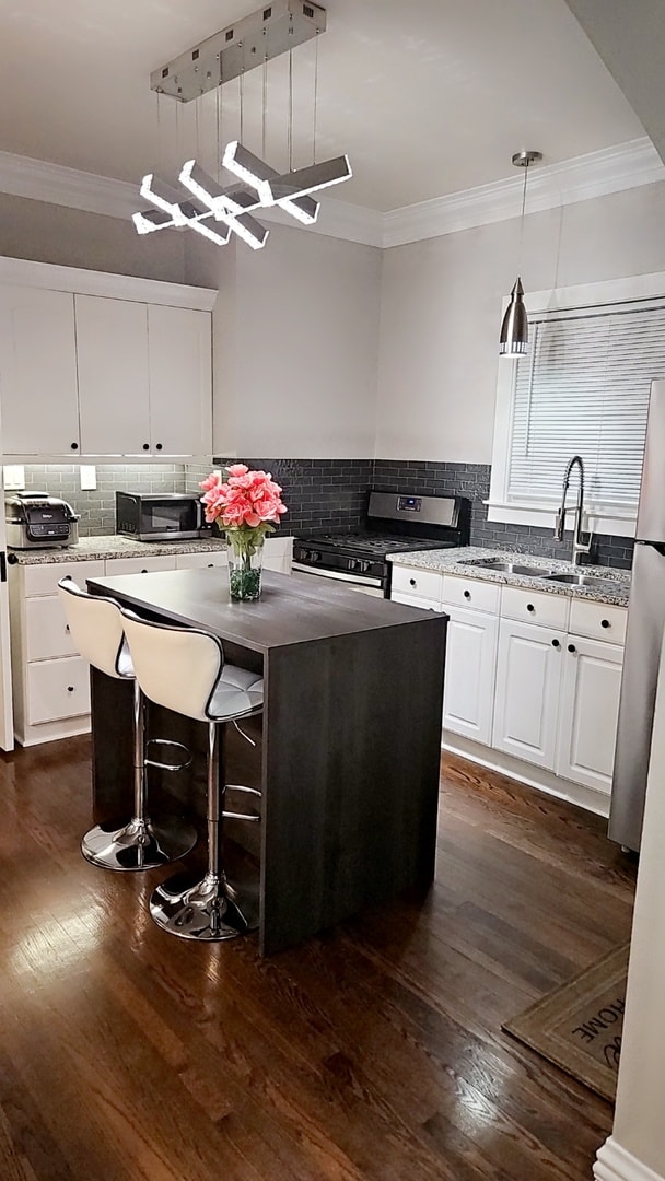 kitchen with stainless steel appliances, hanging light fixtures, a kitchen island, and sink