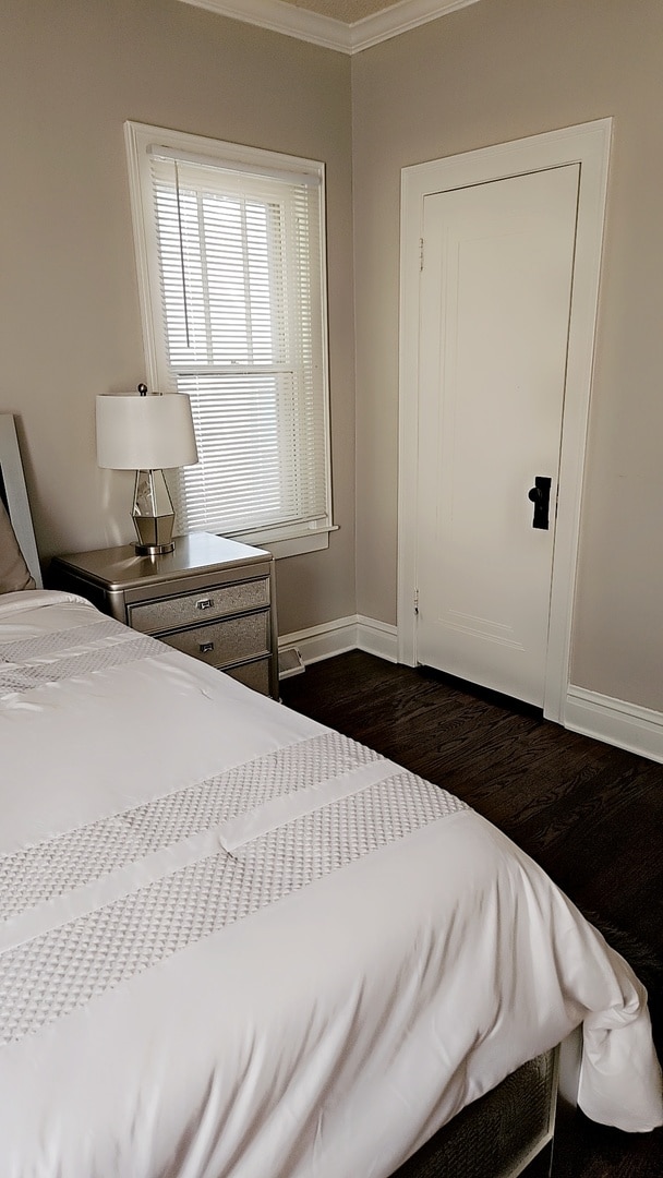 unfurnished bedroom featuring dark hardwood / wood-style floors and ornamental molding