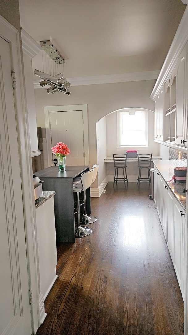 interior space featuring ornamental molding, an inviting chandelier, and dark hardwood / wood-style flooring