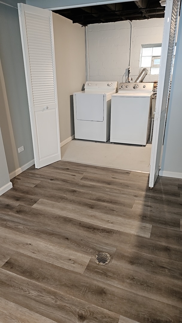 clothes washing area featuring dark hardwood / wood-style flooring and washer and clothes dryer