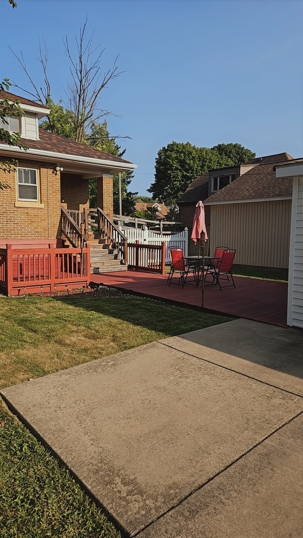 wooden terrace featuring a yard and a patio area