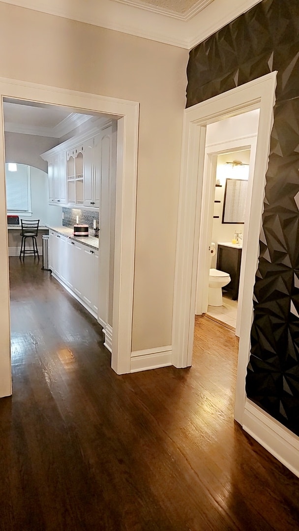 hallway featuring crown molding and dark wood-type flooring