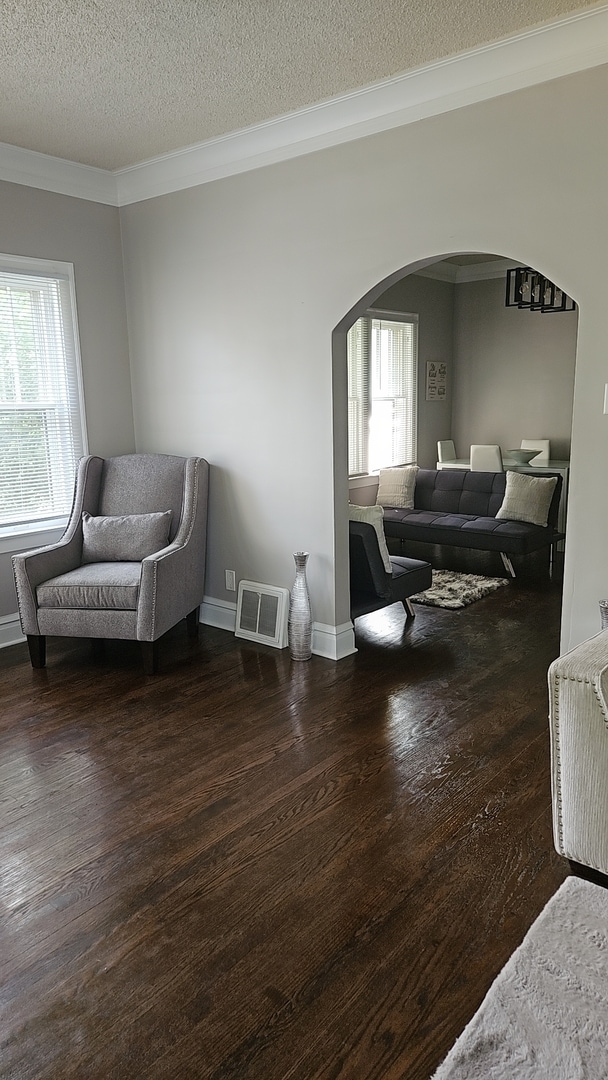 sitting room featuring ornamental molding, a textured ceiling, plenty of natural light, and dark hardwood / wood-style flooring