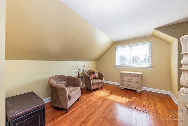 living area with light wood-type flooring and lofted ceiling