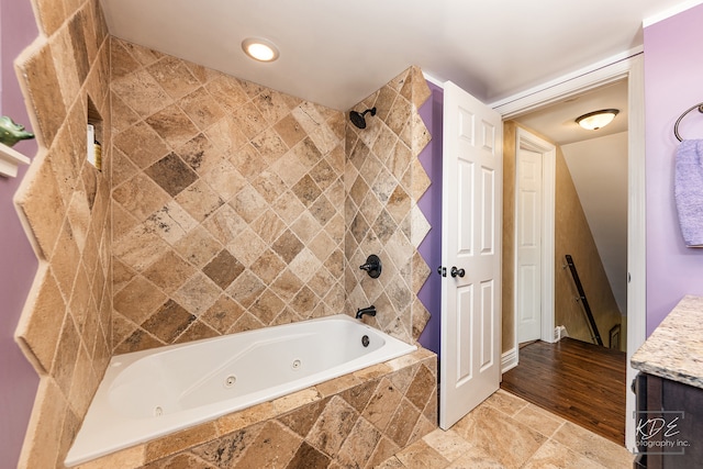 bathroom featuring hardwood / wood-style floors, tiled shower / bath, and vanity