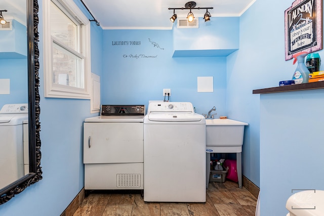 laundry area featuring washer and clothes dryer and crown molding