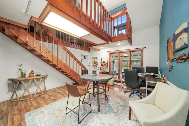 dining area featuring hardwood / wood-style floors, a high ceiling, and french doors