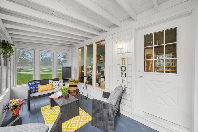 sunroom / solarium featuring beamed ceiling