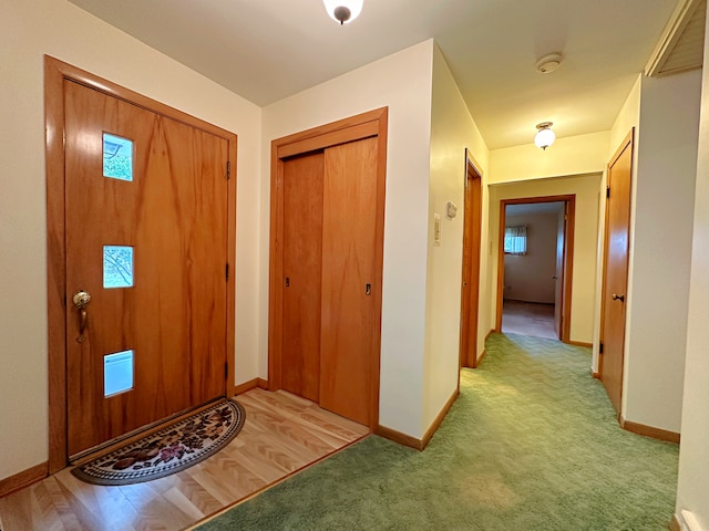 foyer entrance featuring light colored carpet