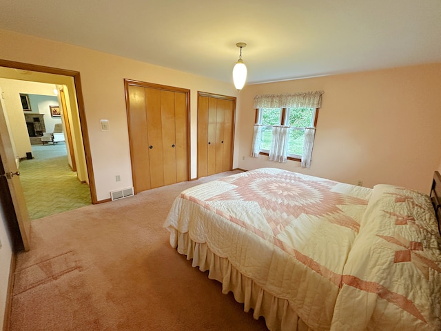 carpeted bedroom featuring multiple closets