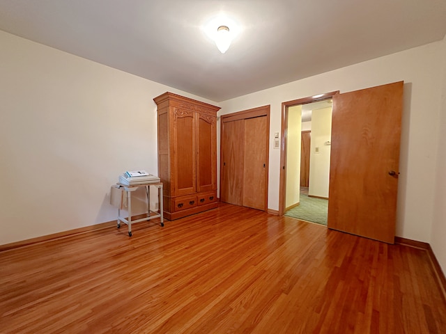 unfurnished bedroom with hardwood / wood-style floors and a closet