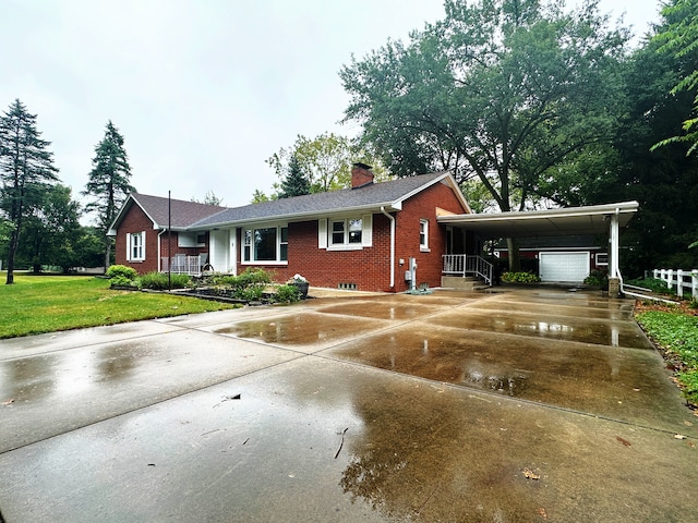 view of front of property featuring a carport, a front lawn, and a garage