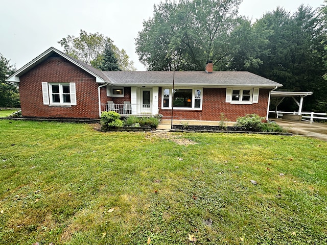 ranch-style home featuring a front yard, covered porch, and a carport