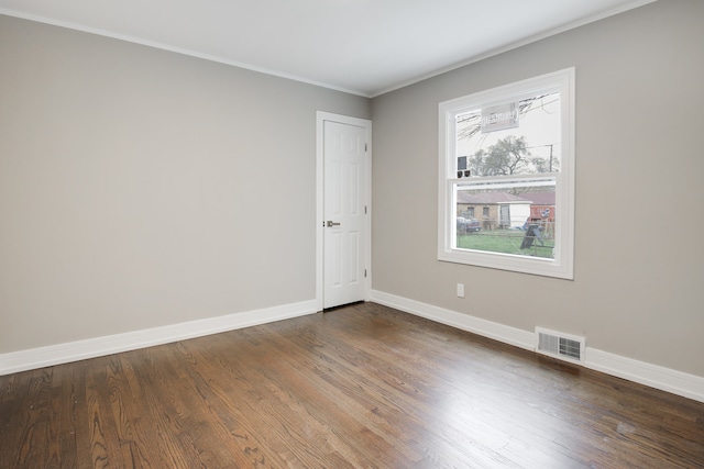 spare room with dark hardwood / wood-style flooring and crown molding