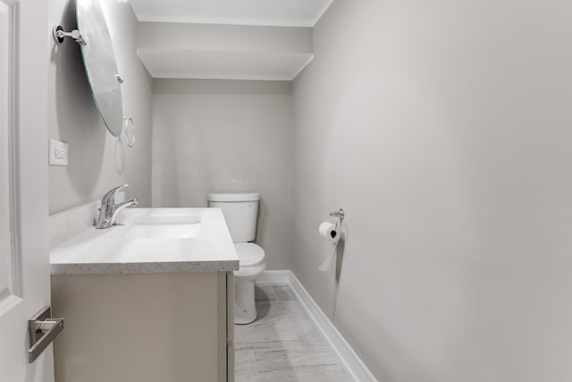 bathroom featuring ornamental molding, vanity, and toilet