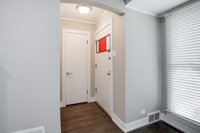 entryway with dark wood-type flooring and crown molding