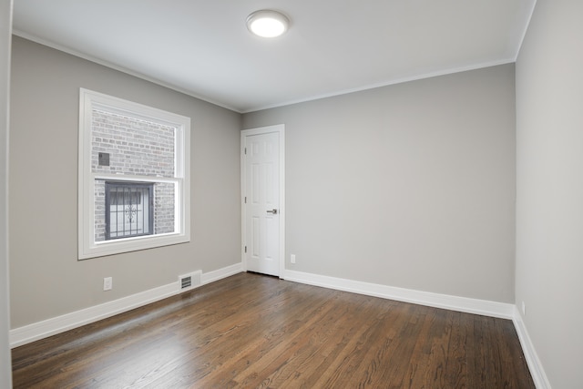 unfurnished room with dark hardwood / wood-style flooring and ornamental molding