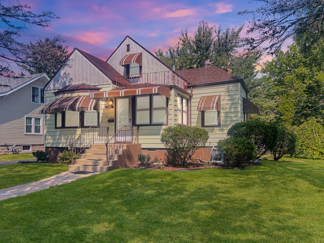 view of front of house featuring roof with shingles and a front yard