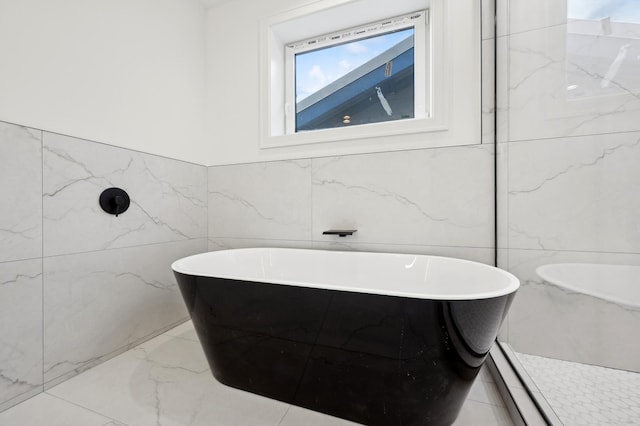 bathroom featuring tile walls and a tub