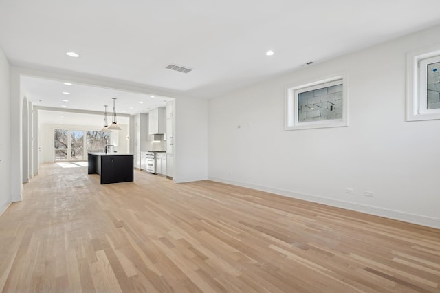 unfurnished living room with sink and light wood-type flooring