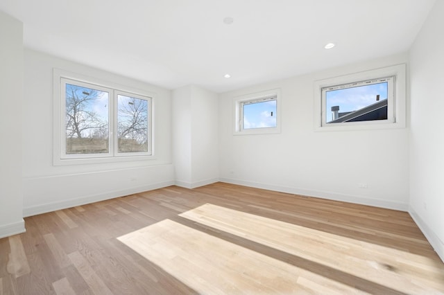 spare room featuring a wealth of natural light and light hardwood / wood-style flooring