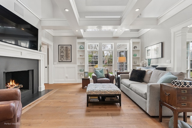 living room featuring coffered ceiling, beamed ceiling, crown molding, built in features, and light hardwood / wood-style flooring