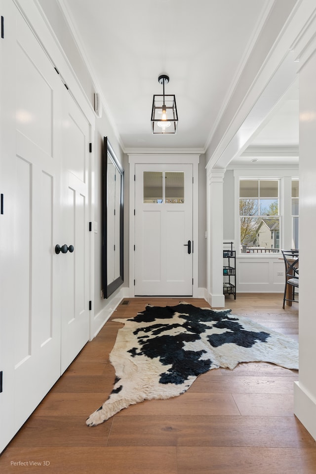 foyer entrance featuring ornamental molding and wood-type flooring