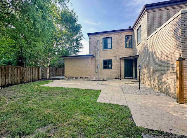 back of property with a patio and a yard