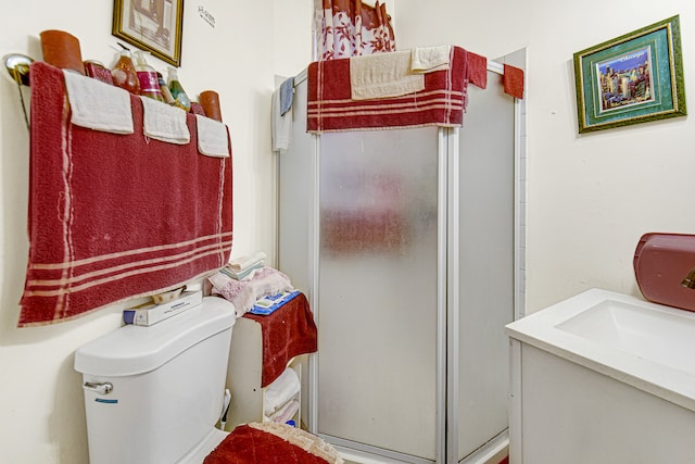 bathroom with toilet, an enclosed shower, and vanity