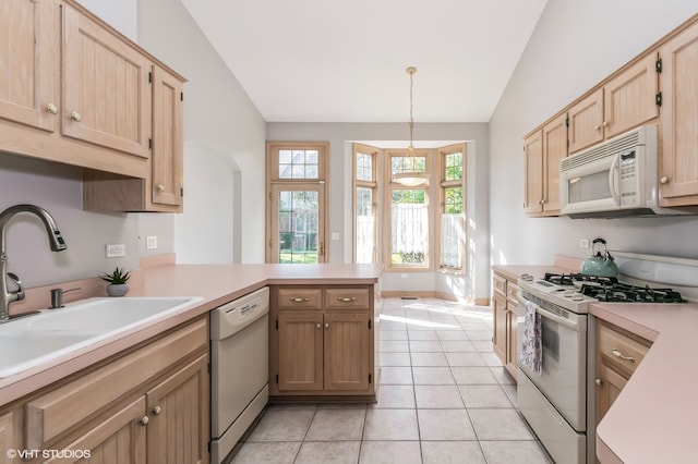 kitchen featuring a healthy amount of sunlight, white appliances, decorative light fixtures, kitchen peninsula, and lofted ceiling