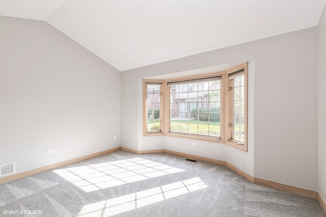 unfurnished room with lofted ceiling and light colored carpet