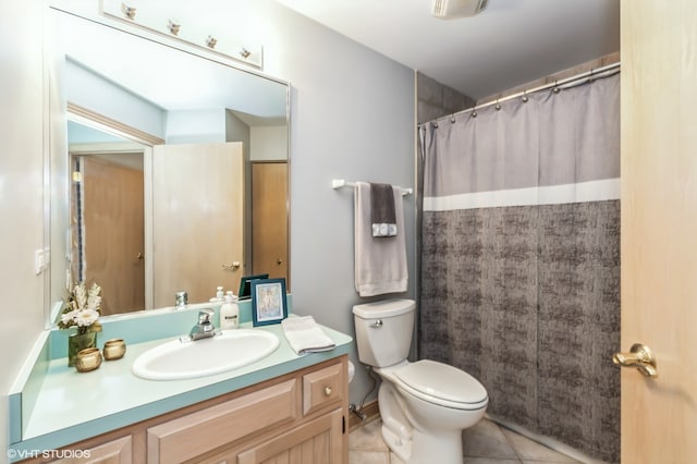 bathroom featuring tile patterned flooring, vanity, toilet, and walk in shower