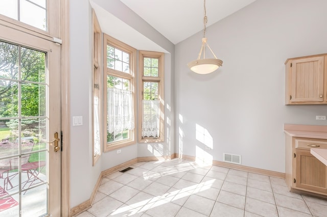 unfurnished dining area with high vaulted ceiling and light tile patterned floors