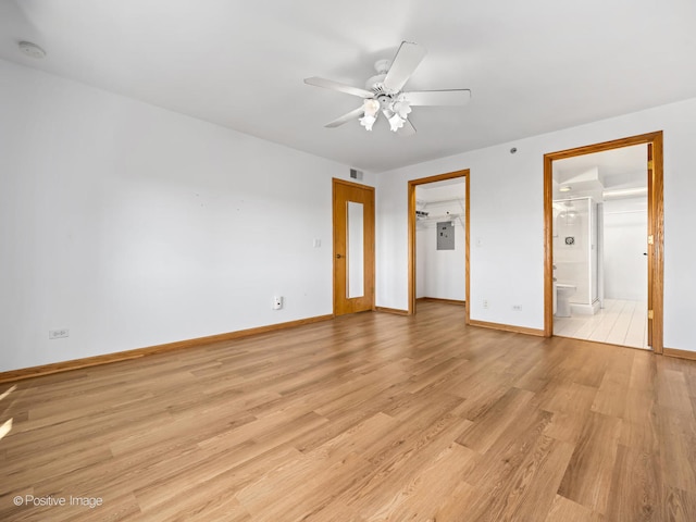 unfurnished bedroom featuring light hardwood / wood-style flooring, ensuite bath, ceiling fan, a closet, and a walk in closet