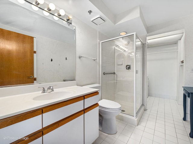 bathroom featuring vanity, toilet, tile patterned floors, and walk in shower