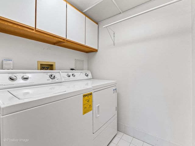 laundry room featuring cabinets, light tile patterned floors, and independent washer and dryer