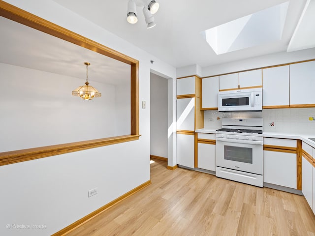 kitchen with pendant lighting, white appliances, light hardwood / wood-style flooring, an inviting chandelier, and white cabinets