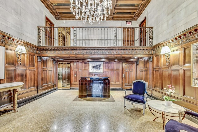 entrance foyer with coffered ceiling, an inviting chandelier, and a high ceiling