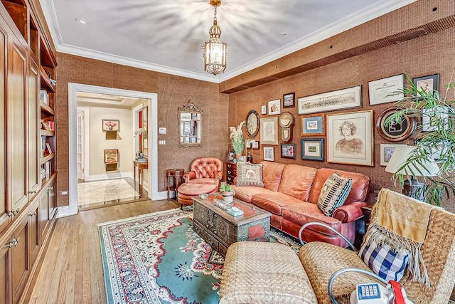 living room featuring crown molding, light hardwood / wood-style flooring, and a chandelier