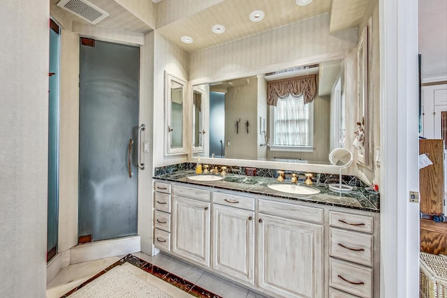 bathroom with tile patterned flooring, walk in shower, and vanity