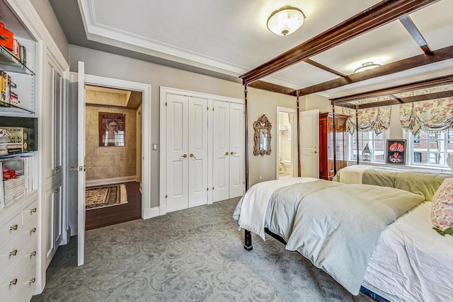 carpeted bedroom with ensuite bathroom and beamed ceiling