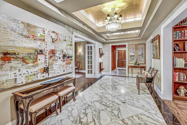 interior space with a tray ceiling, ornamental molding, and a notable chandelier