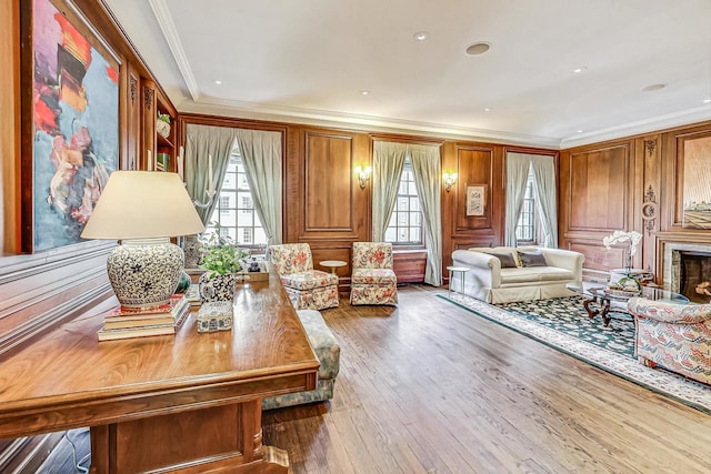 living room featuring hardwood / wood-style floors, a wealth of natural light, and ornamental molding