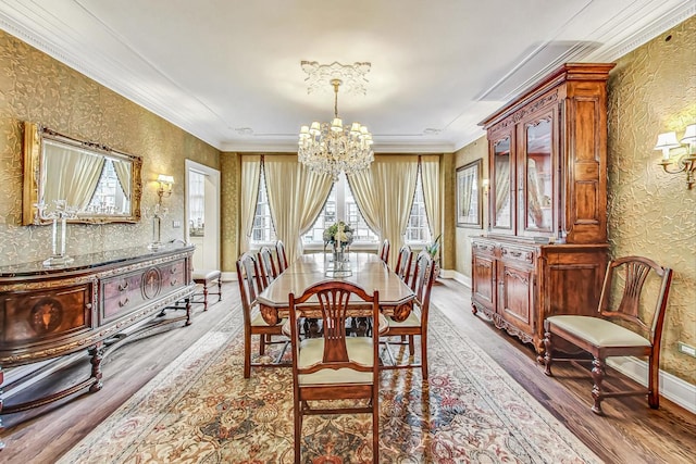 dining room with wood-type flooring, crown molding, and a notable chandelier