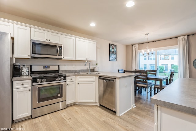 kitchen featuring a chandelier, sink, white cabinets, hanging light fixtures, and stainless steel appliances