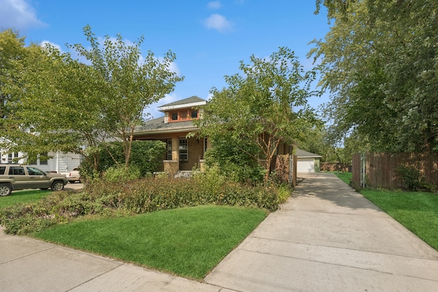 view of property hidden behind natural elements featuring a front yard and a garage