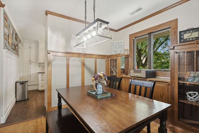 dining room featuring ornamental molding, dark hardwood / wood-style floors, and a notable chandelier