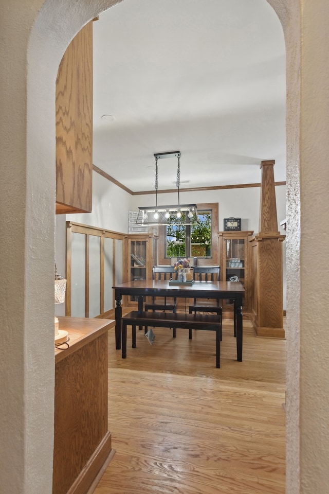 dining room with crown molding and light hardwood / wood-style flooring