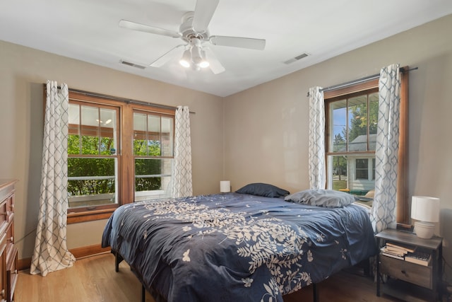 bedroom featuring multiple windows, ceiling fan, and hardwood / wood-style floors